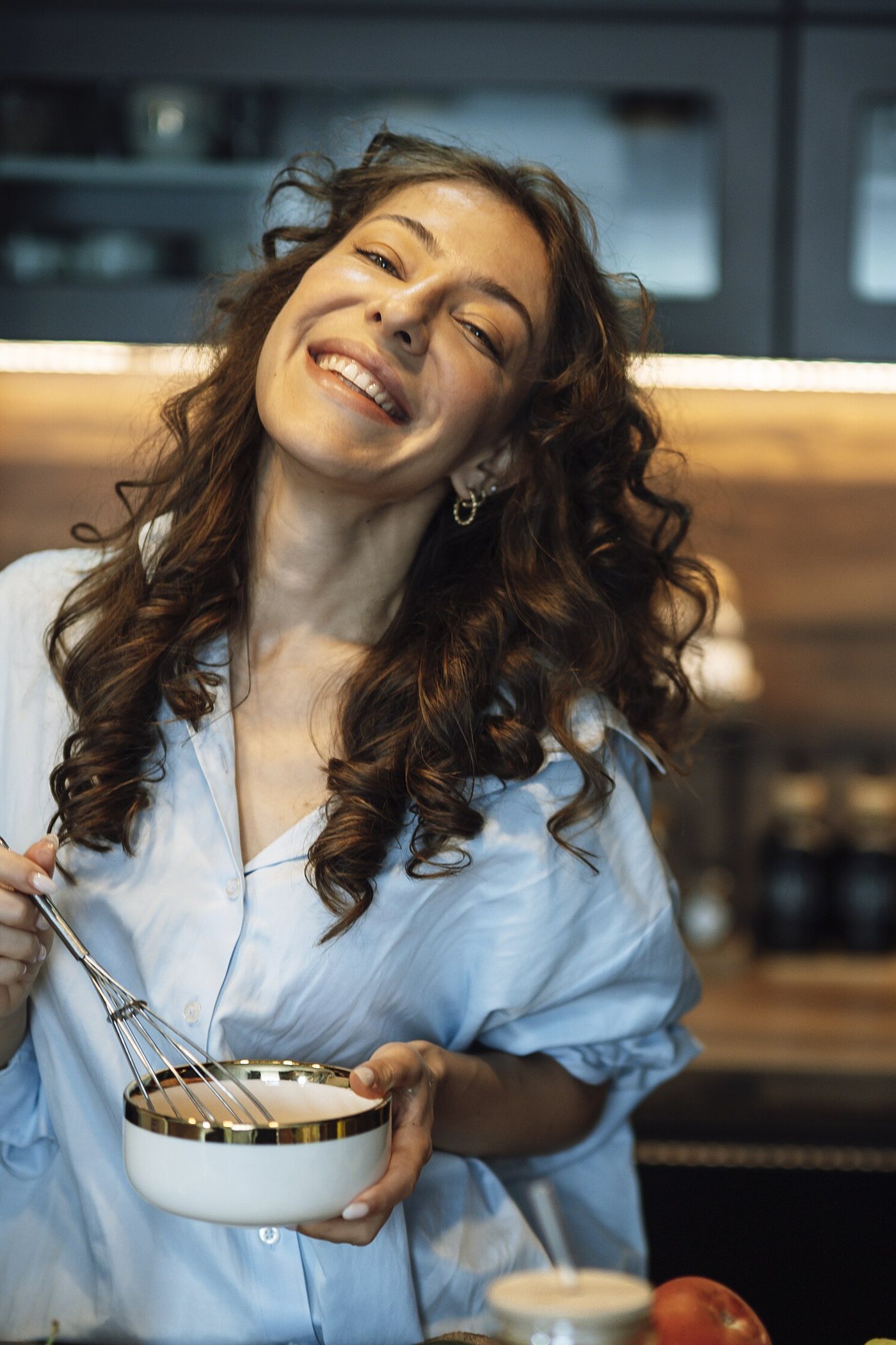 Maya Ellison smiling while cooking in her kitchen