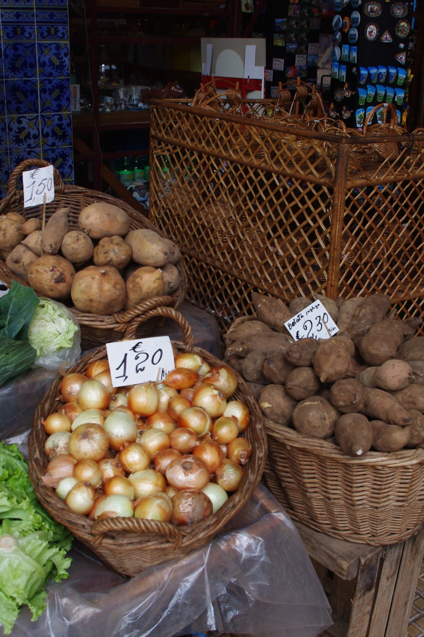 Hands choosing fresh tomatoes and greens at a market stall
