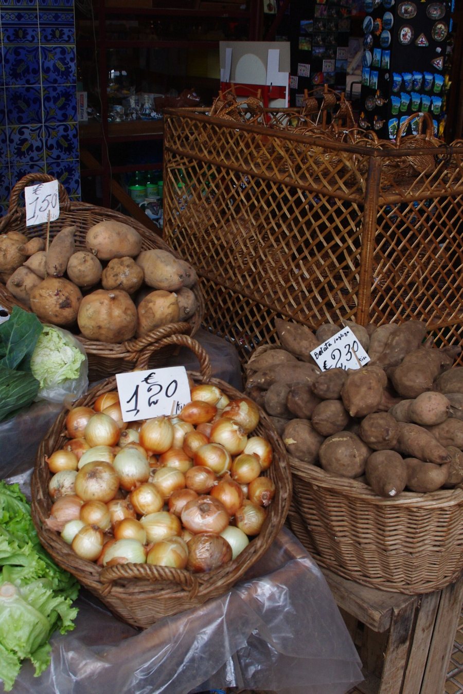 Hands choosing fresh tomatoes and greens at a market stall