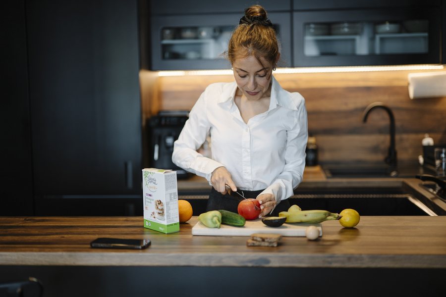 Maya Ellison smiling as she cooks in a bright white kitchen