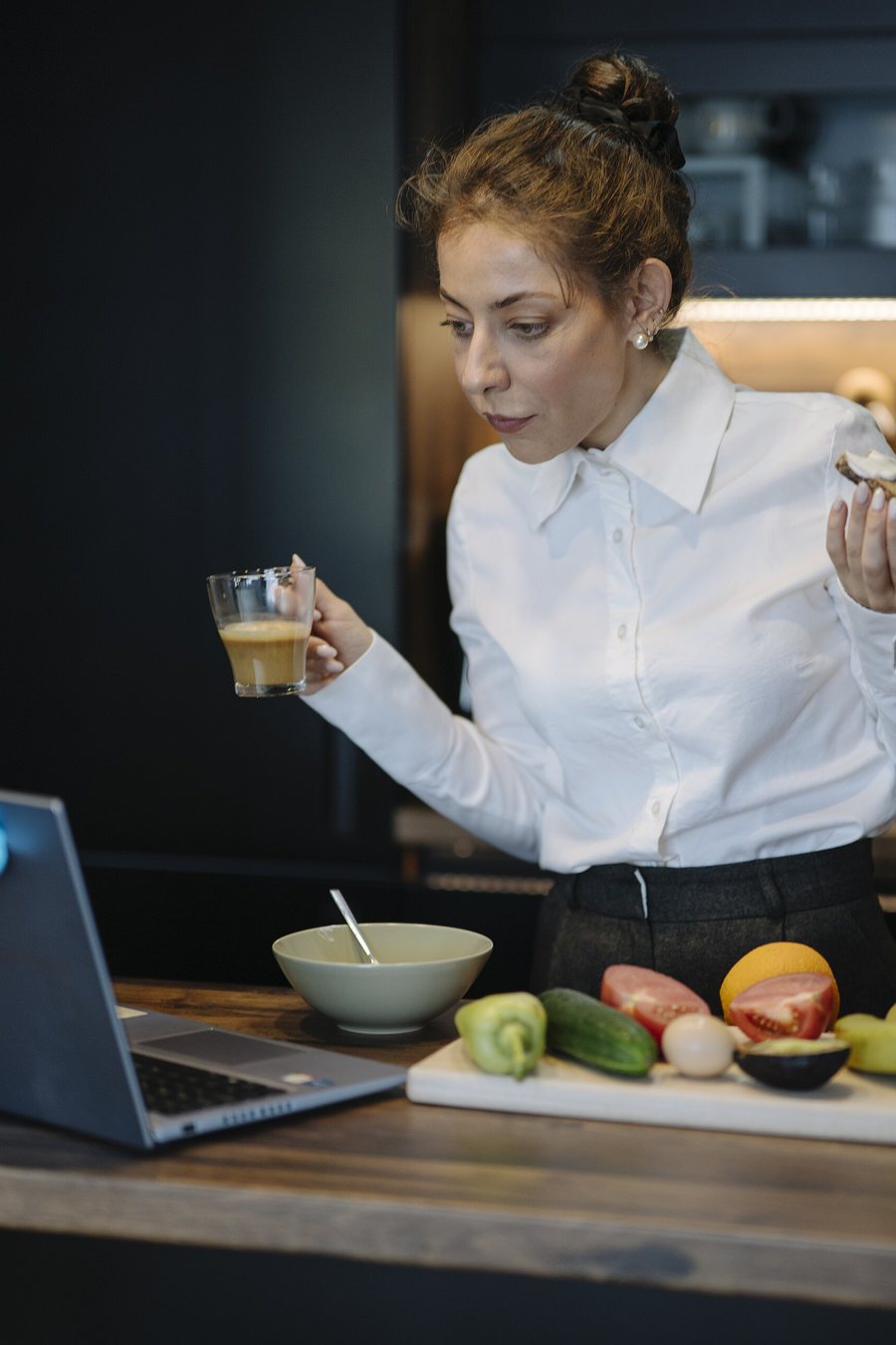 Maya Ellison lifting the lid from a pot on a marble counter