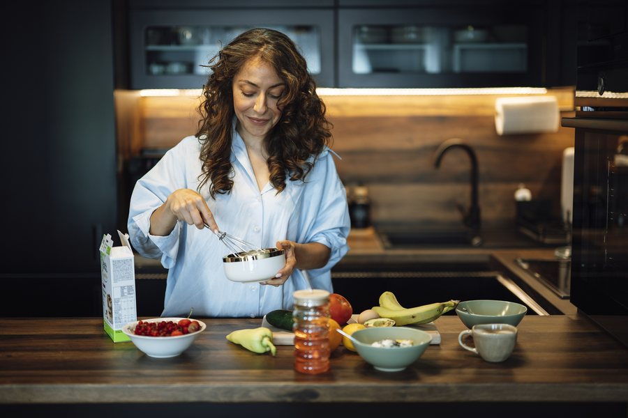 Maya Ellison cooking at the stove in a bright, open kitchen